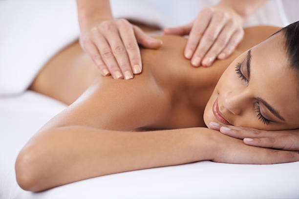 Ridding myself of some tension A young woman receiving a massage from a massage professional massaging photos stock pictures, royalty-free photos & images