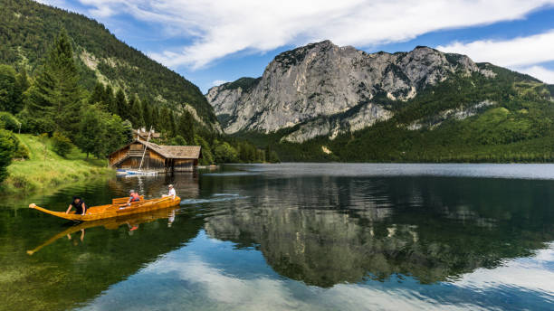 Riding a wooden boat on a beautiful lake Beautiful lake, wooden boat, boat house, hills ausseerland stock pictures, royalty-free photos & images