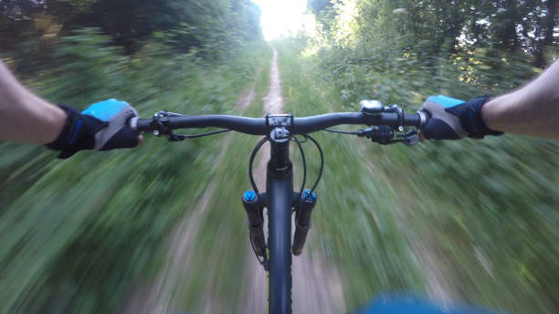 Riding downhill through woods on mountain bike Oxfordshire stock photo