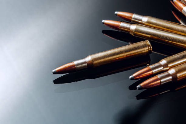 Rifle bullets or cartridges on black shiny background stock photo