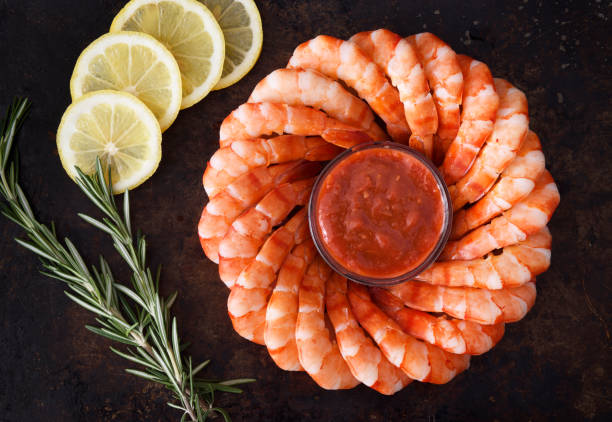 Ring of shrimps Ring of tiger shrimps with cocktail sauce and lemon slices cocktail sauce stock pictures, royalty-free photos & images