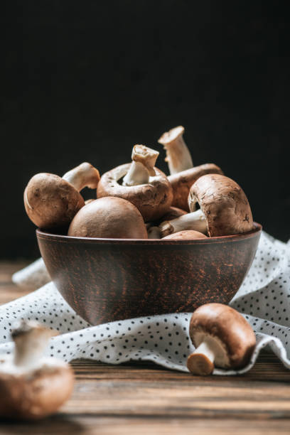 mûrs : champignon champignons dans un bol sur la table en bois isolé sur fond noir - champignon et en studio et fond noir photos et images de collection