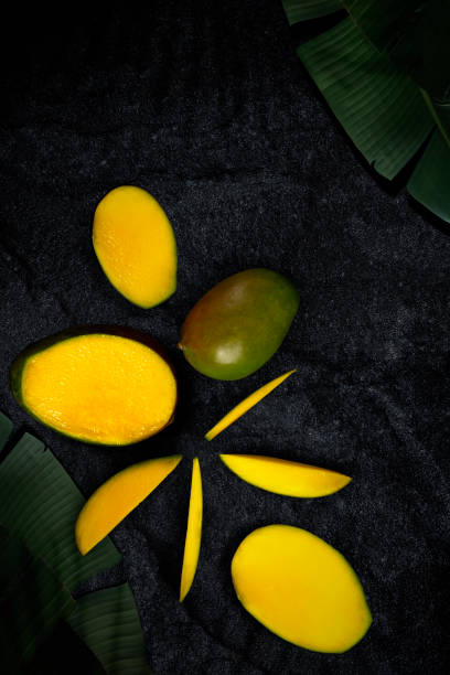 Ripe mango on the black textured table. View from above. Copy space. stock photo
