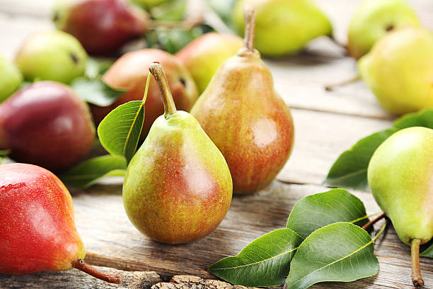 Ripe pears on grey wooden table stock photo
