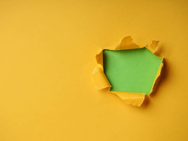 Ripped Paper Hole with green and yellow coloured background stock photo