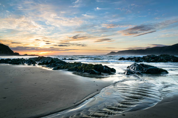 Rippling Stream on a Beach This is a pictur of a stream on a beach in Donegal Ireland at sunset. Sea cliffs can be seen in the distance. inishowen peninsula stock pictures, royalty-free photos & images