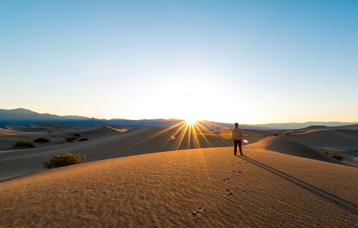 Facing the rising sun on sand dunes of Death Valley