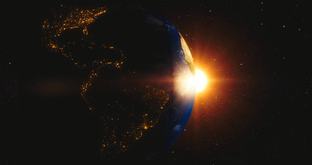 Rising sun behind planet earth stock photo