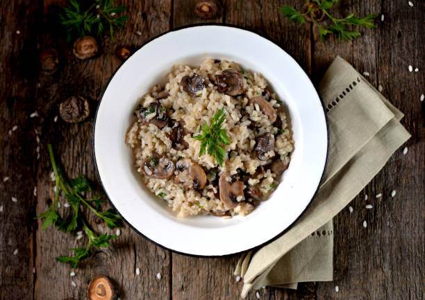 Risotto with mushrooms on an old wooden background. Rustic style. stock photo