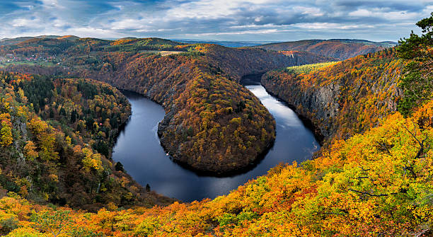 River canyon with dark water and autumn colorful forest River canyon with dark water and autumn colorful forest. Horseshoe bend, Vltava river, Czech republic. Beautiful landscape with river. Maj lookout. vltava river stock pictures, royalty-free photos & images