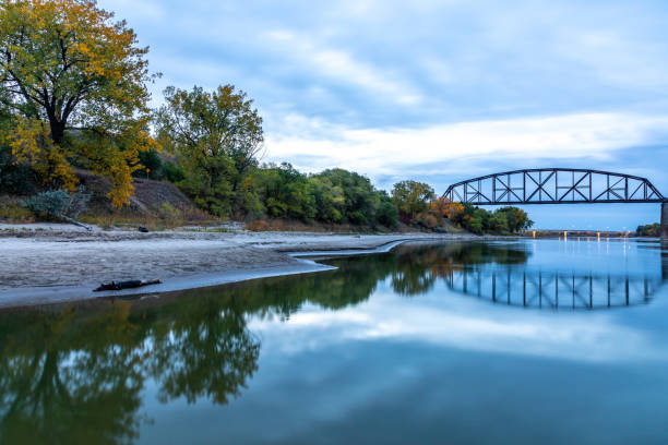Riverbank and Bridge Span in Bismark, North Dakota Early-morning view along east bank of the Missouri River in Bismark, North Dakota. north dakota stock pictures, royalty-free photos & images