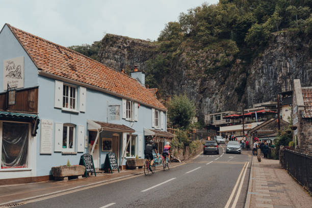 Road going through Cheddar village, Somerset, UK. Cheddar, UK - July 26, 2020: Road going through Cheddar, a village famous for its Gorge and is the birthplace of world famous cheese. somerset england stock pictures, royalty-free photos & images