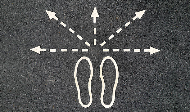 Road human footprints from them going in different directions arrows. stock photo