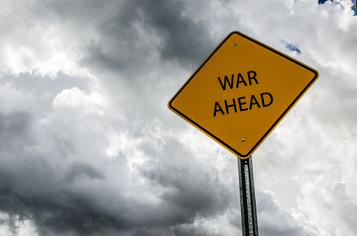 Road sign announcing that war is ahead, on a stormy sky