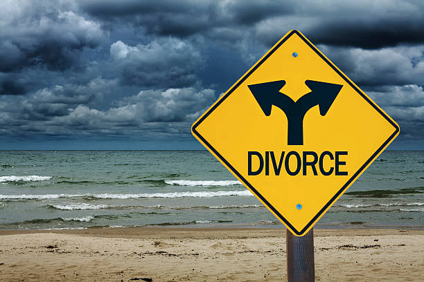 DIVORCE Road Sign with Stormy Sky Future Ahead A street sign or road sign with the word "DIVORCE" ahead. Concept photo of the stormy path ahead in the future of a troubled marriage relationship, Photographed with a stormy sky background and in horizontal format. divorce beach stock pictures, royalty-free photos & images
