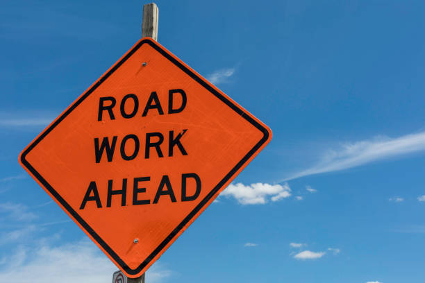 Road Work Ahead Sign Road Work Ahead Sign shown against a bright blue sky road construction stock pictures, royalty-free photos & images