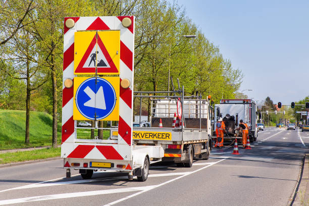 Road works with trucks and traffic signs stock photo