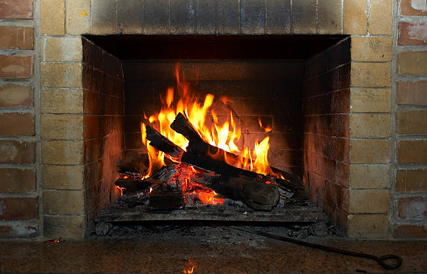 A roaring fireplace with a brick surround stock photo