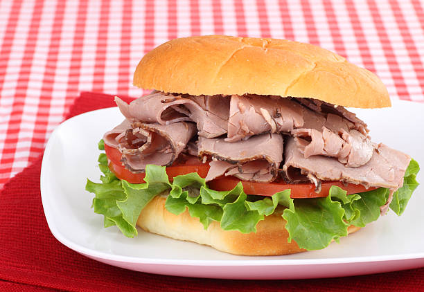 Roast Beef on a Bun Roast beef sandwich on a red place mat roast beef sandwich stock pictures, royalty-free photos & images