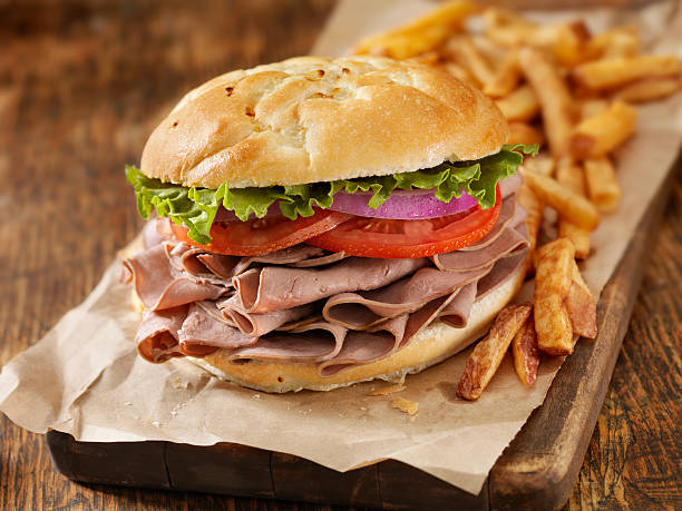 Roast Beef  Sandwich Roast Beef  Sandwich with Lettuce, Tomatoes, Red Onions and French Fries- Photographed on Hasselblad H3D2-39mb Camera roast beef sandwich stock pictures, royalty-free photos & images