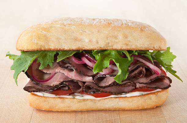 Roast Beef Sandwich Roast Beef sandwich with herb mayonnaise on a ciabatta roll. roast beef sandwich stock pictures, royalty-free photos & images
