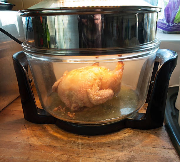 Roast chicken cooking in halogen oven Roast chicken cooking in halogen oven halogen light stock pictures, royalty-free photos & images
