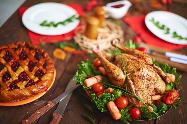 roast chicken on a table with vegetables stock photo