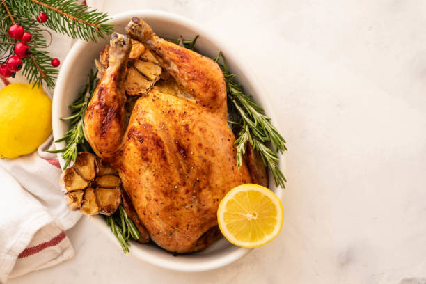 Roast chicken with lemons, garlic and rosemary for Christmas. Christmas concept. Top view. stock photo