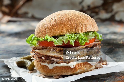 istock Roast Pork Sandwich with Lettuce, Tomato and Mayo on a Ciabatta Bun 1290370896