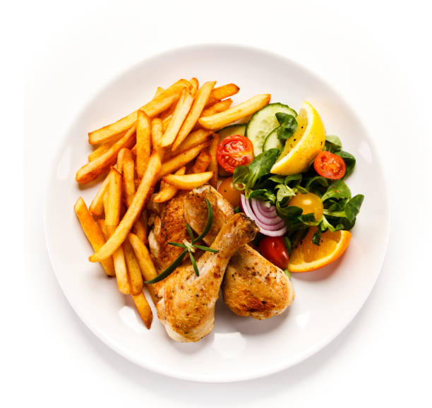 Roasted chicken drumsticks, French fries and vegetables Roasted chicken leg and vegetables chicken meat photos stock pictures, royalty-free photos & images