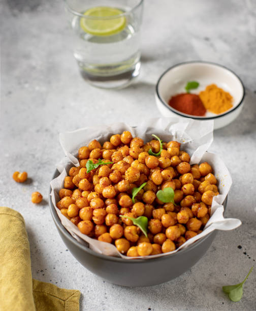 Roasted chickpeas with spices in bowl. healthy food concept. Roasted chickpeas with spices in bowl. healthy food concept. gray concrete background, vertical image crunchy stock pictures, royalty-free photos & images