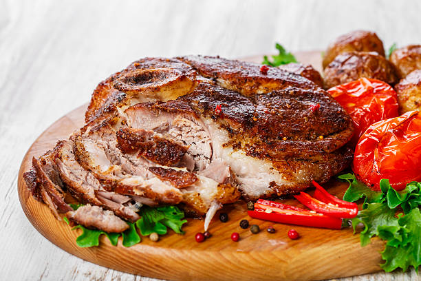 roasted pork shoulder on the bone with potatoes stock photo