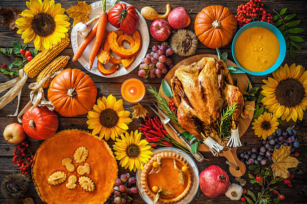 Roasted Thanksgiving Turkey Thanksgiving dinner. Roasted turkey with pumpkins and sunflowers on wooden table thanksgiving food stock pictures, royalty-free photos & images