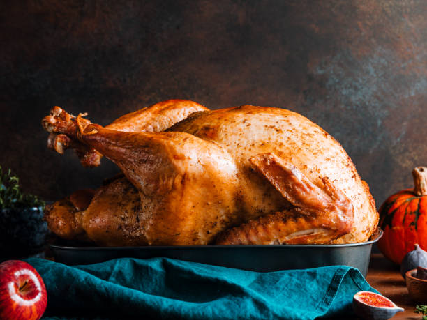 Roasted whole turkey on a table with apple, pumpkin and figs for family Thanksgiving Holiday.  thanksgiving turkey stock pictures, royalty-free photos & images