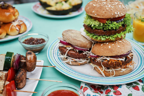 Roasting Vegan Skewers, Vegan Burger Patties and Vegetables on BBQ Grill stock photo