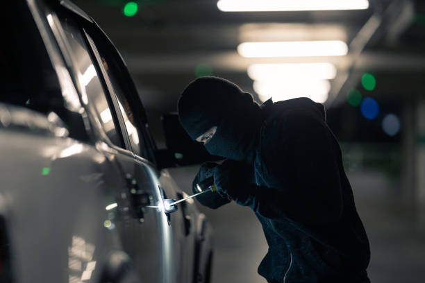 Robbers are robbing cars. Parked in the night parking stock photo