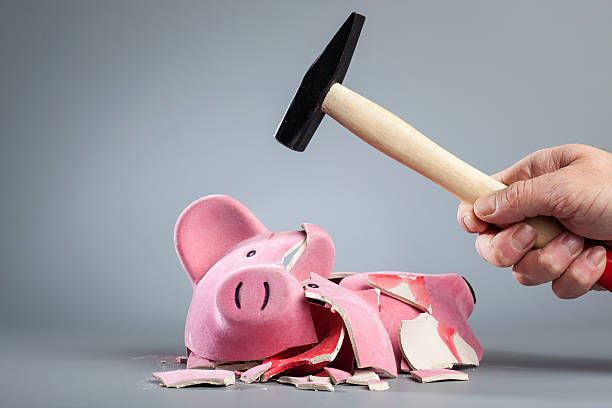 Robbing piggy bank with hammer stock photo