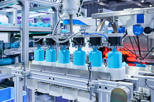 Robot Arm Gripping Bottles at Production Line stock photo