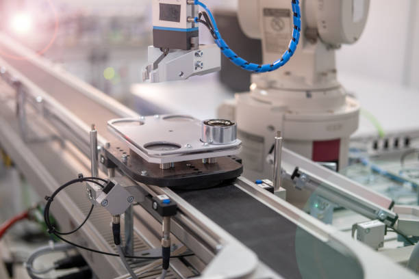 Robot picks up the product from automated car on the manufacturing line stock photo
