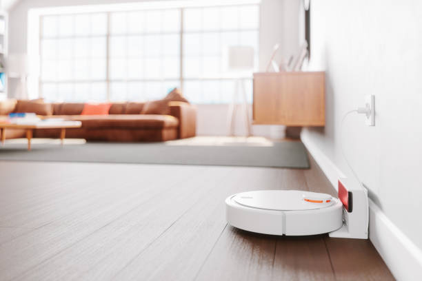Robot Vacuum Cleaner In A Modern Living Room Close-up shot of a robot vacuum cleaner in a modern living room. automatic photos stock pictures, royalty-free photos & images