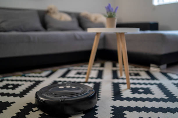 라미네이트 목재 바닥에 로봇 진공 청소기, 거실에서 스마트 로봇 자동화 무선 청소 기술 기계 - mitrovic 뉴스 사진 이미지