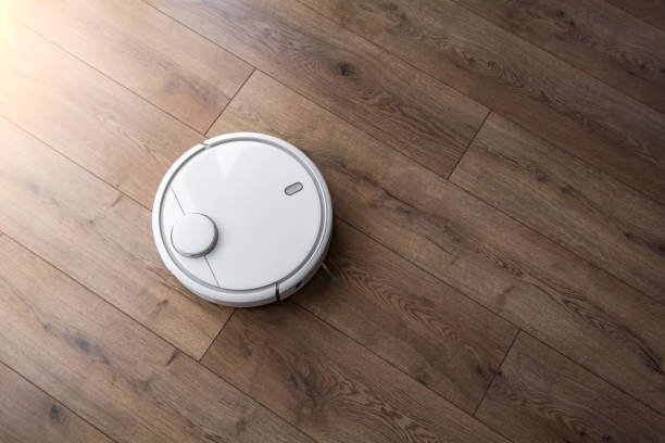Robot vacuum cleaner on the laminate. View from above. Cleaning in the apartment. stock photo