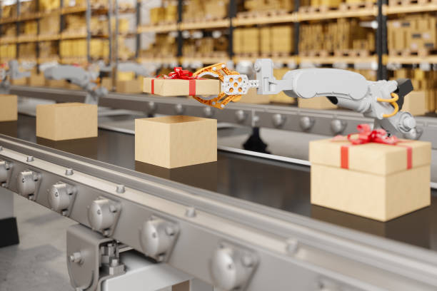 Robotic Arm Putting The Cover Of Gift Box On The Conveyor Belt Robotic Arm Putting The Cover Of Gift Box On The Conveyor Belt conveyor belt photos stock pictures, royalty-free photos & images