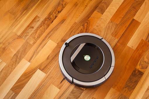 Robotic Vacuum Cleaner On Laminate Wood Floor Smart Cleaning