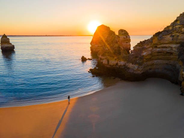 rock formations with sea at ponta da piedade at sunrise - people portugal imagens e fotografias de stock