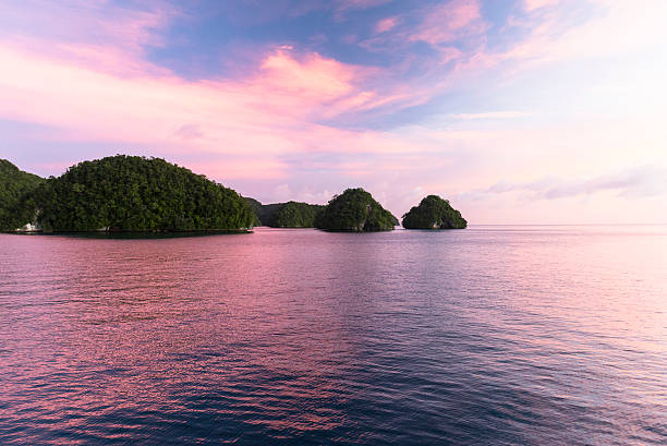 Rock Islands - Palau, Micronesia Stunning sunset at the Rock Islands of Palau, also called Chelbacheb, are a small collection of limestone or coral uprises, ancient relics of coral reefs that violently surfaced to form Islands in Palau's Southern Lagoon, between Koror and Peleliu, and are now an incorporated part of Koror State. There are between 250 to 300 islands in the group according to different sources, with an aggregate area of 47 square kilometers (18 sq mi) and a height up to 207 metres (679 ft). They are a World Heritage Site since 2012. babeldaob island stock pictures, royalty-free photos & images
