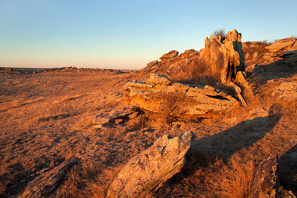Warm morning sunlight hits a rock outcropping in the hilly plains of Pawnee National Grasslands in northern Colorado.