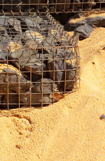 Rock retaining wall rock retaining blocks in cage to stop erosion of beach dune from storm that damaged housing at Wamberal in 2016 erosion control stock pictures, royalty-free photos & images