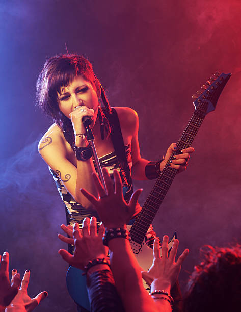 Rock star Female singer and guitarist at a rock concert rock musician stock pictures, royalty-free photos & images