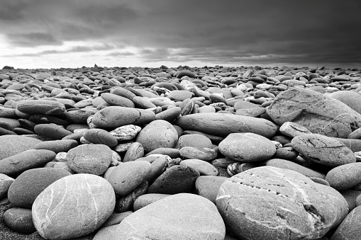 Black and white of a rocky beach. Slight grain.